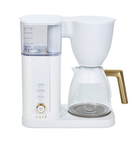 White coffee maker with glass carafe and gold handle.