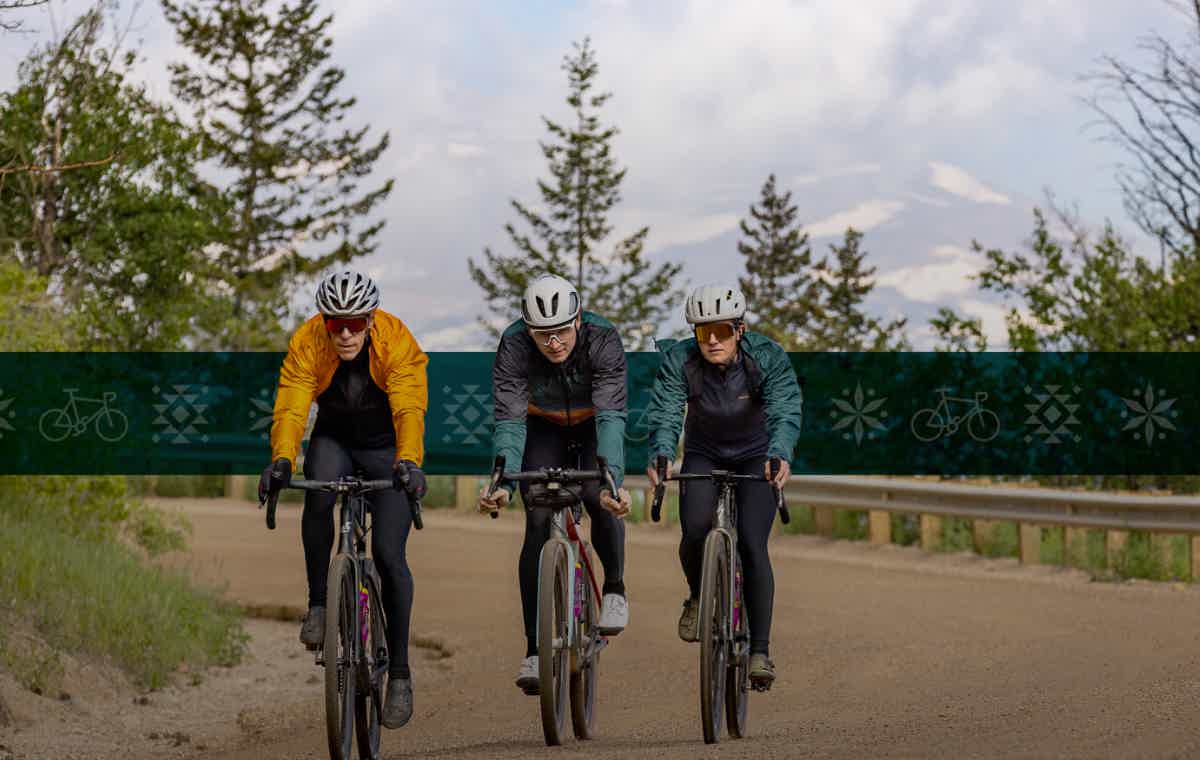 Trio of cyclists on a gravel road in the fall while wearing PEARL iZUMi gear