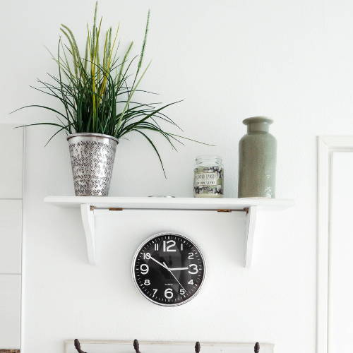 artificial grass plant in a silver metallic vase decorated on a shelf 