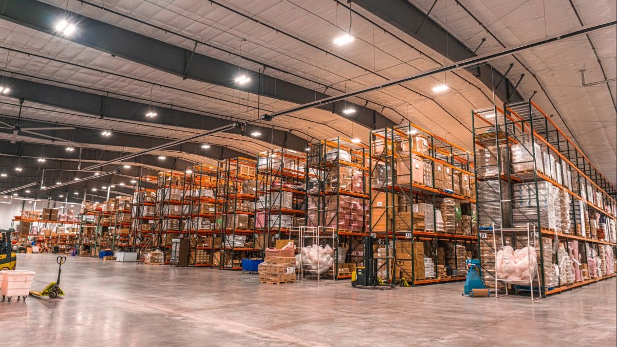 A spacious warehouse filled with stacked shelves and various packaged goods.