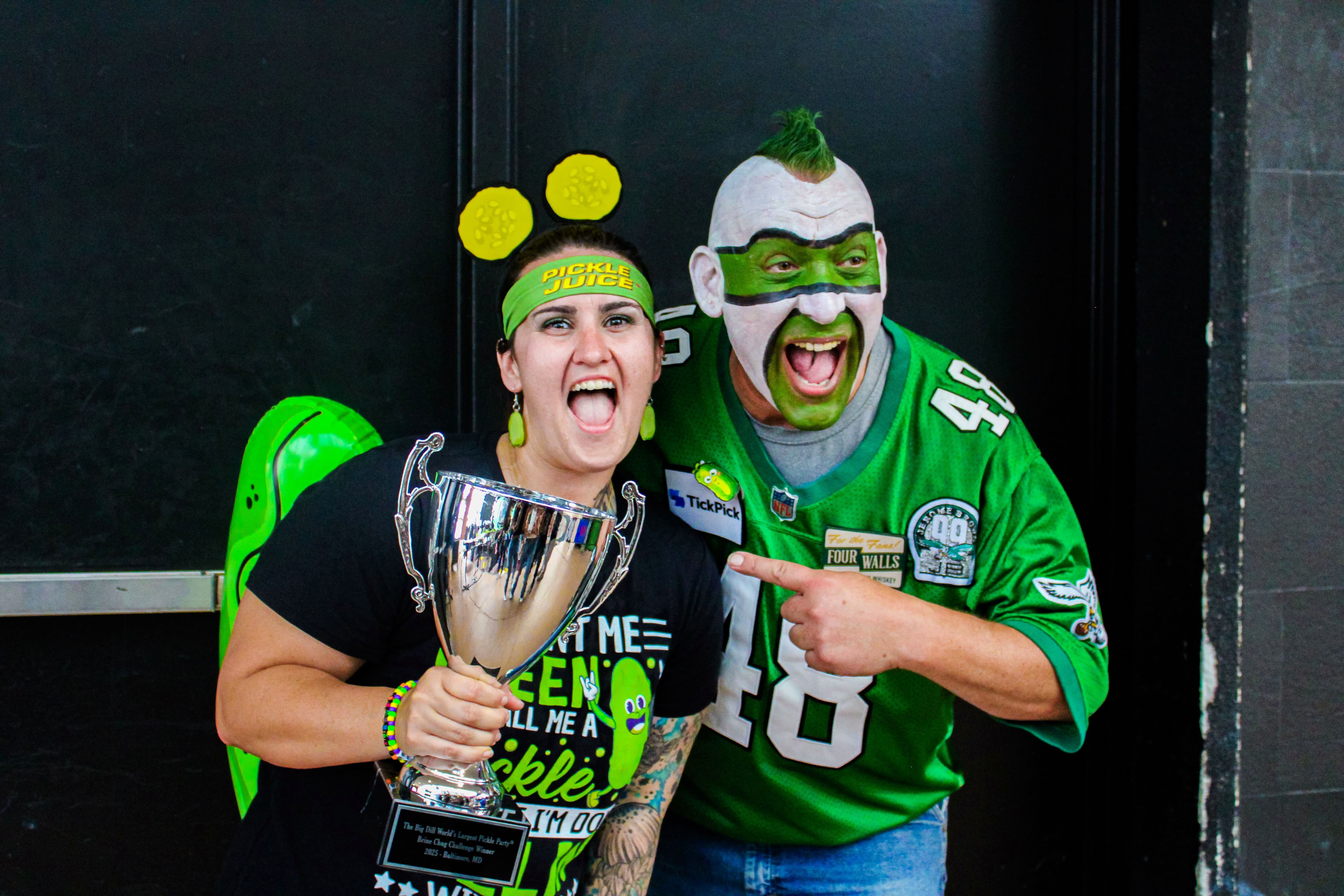 Philadelphia sports personality Jamie Pagliei celebrates winning the Brine Chug Challenge presented by Pickle Juice at The Big Dill pickle festival, Power Plant Live!, Baltimore Maryland 2025.
