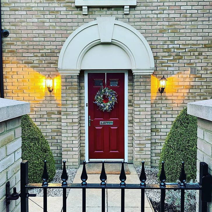 Lavender wreath styled on red door from a distance 