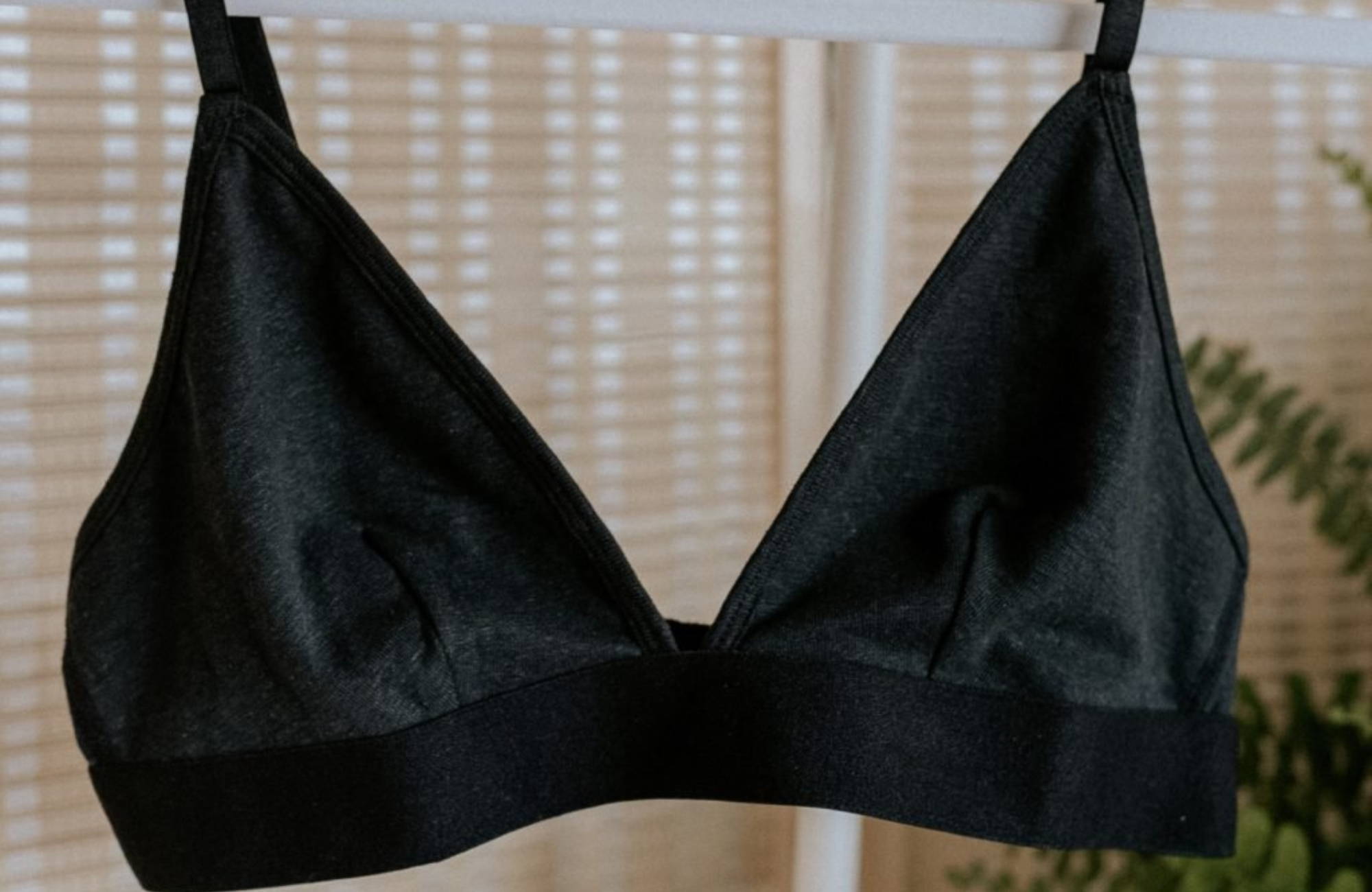 black bralette hanging in front of curtained window