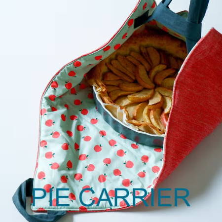 An apple pie in a hand-made carrier bag for pies sewn out of apple and red fabric