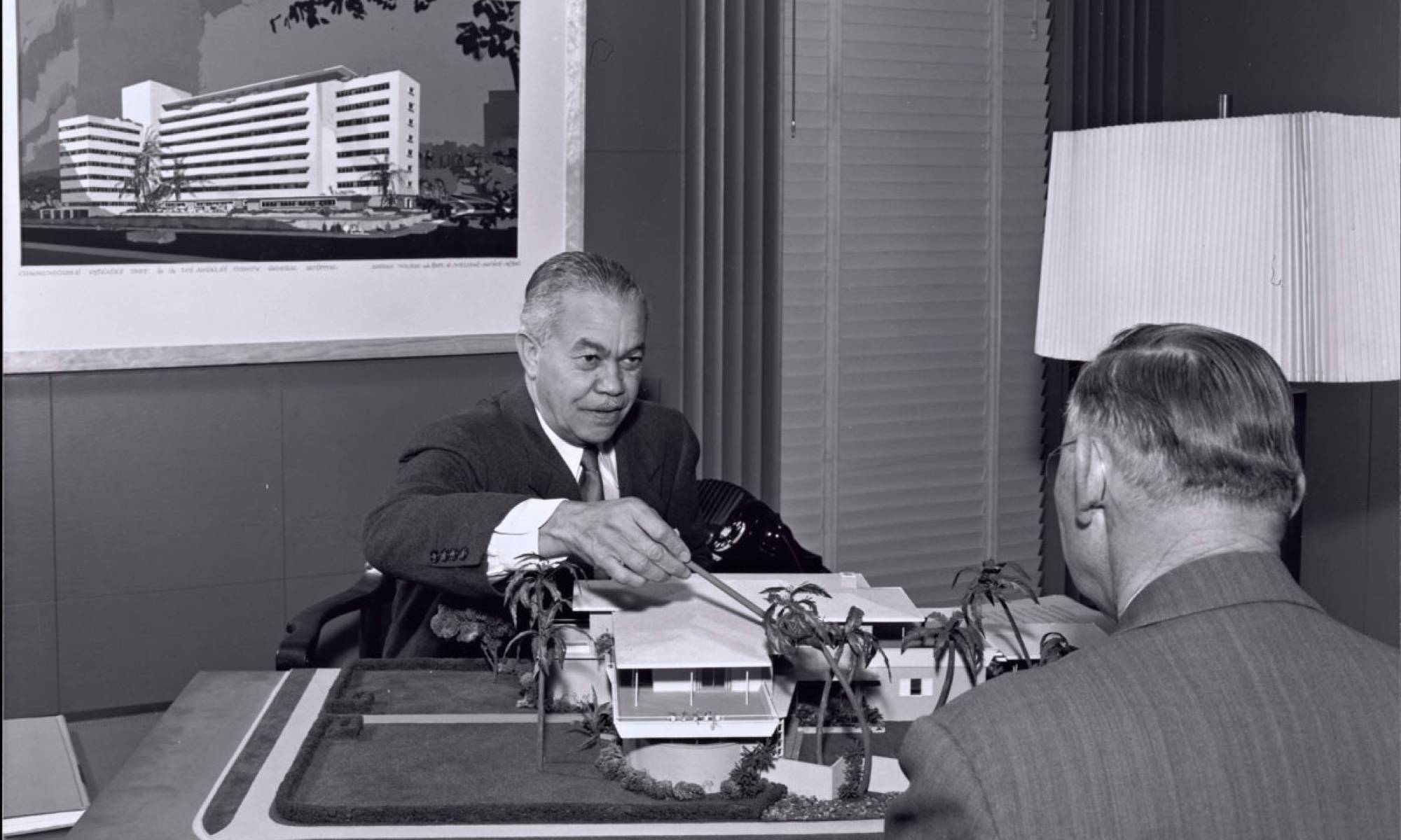 Paul Revere Williams in his office with a model of a mid century modern home