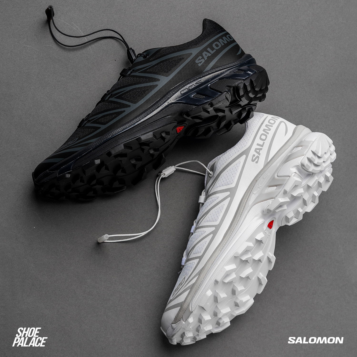 Two pairs of Salomon shoes in black and white on a gray background.