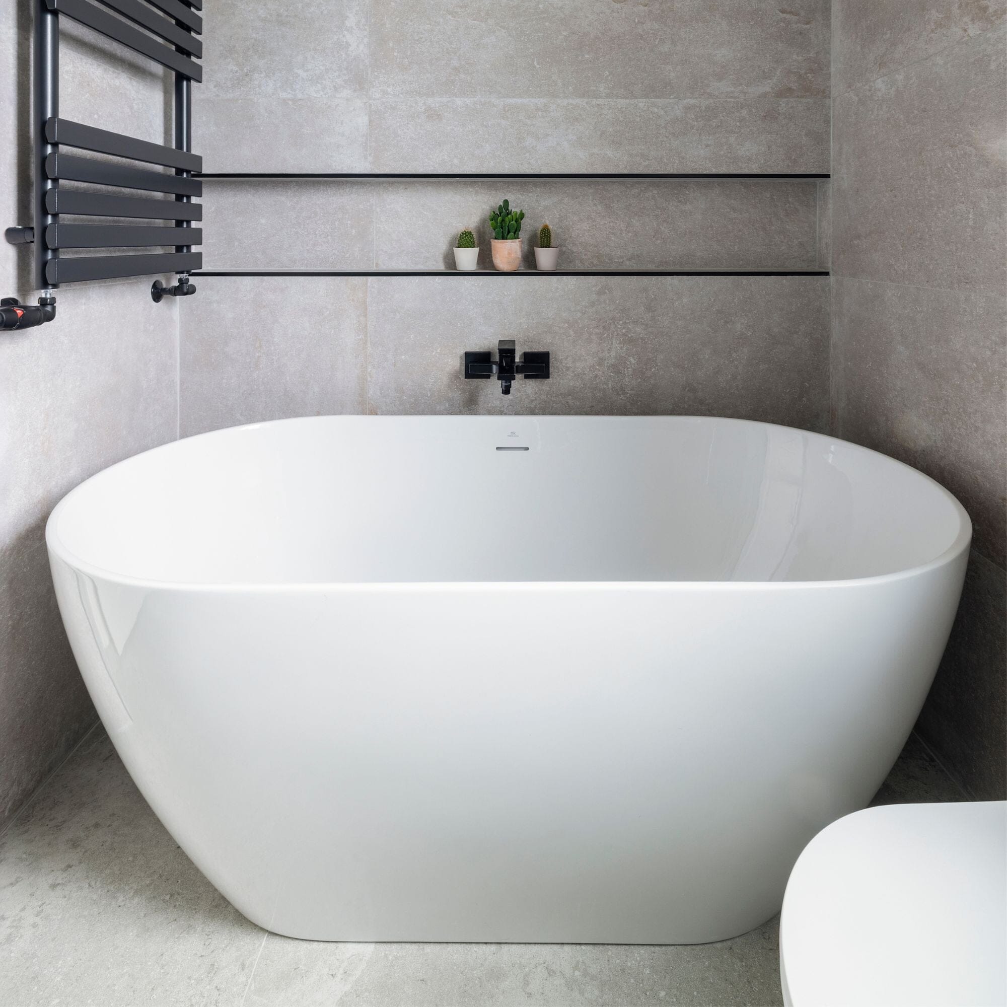 Modern white bathtub in a minimalist bathroom setting.