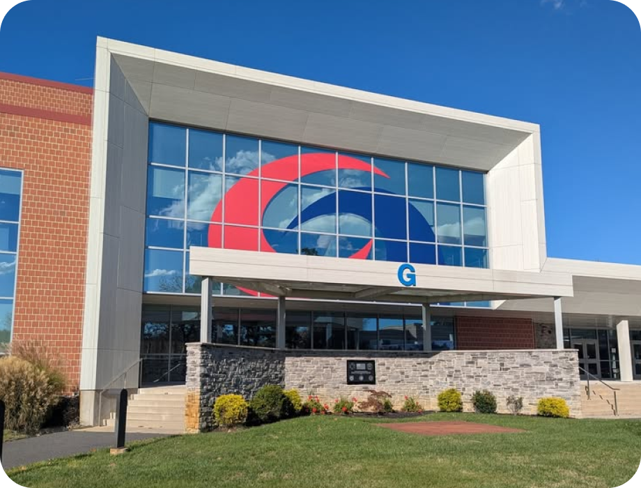 Modern building exterior with large windows and a colorful logo.