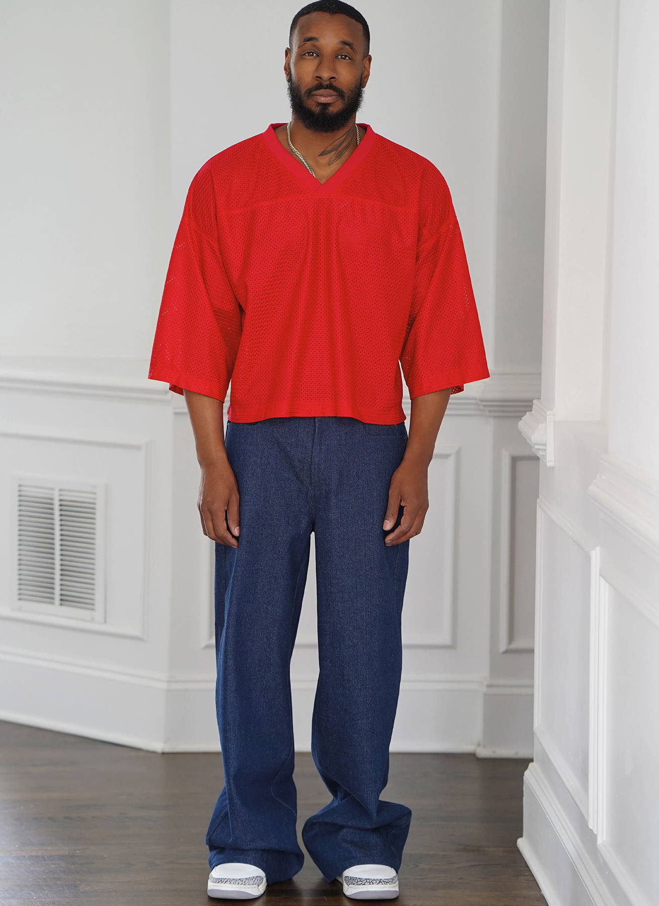 Male model in red shirt and denim pants