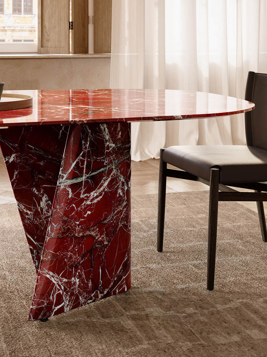 A modern Traverso red marble table by Lema with a unique base and a black chair.