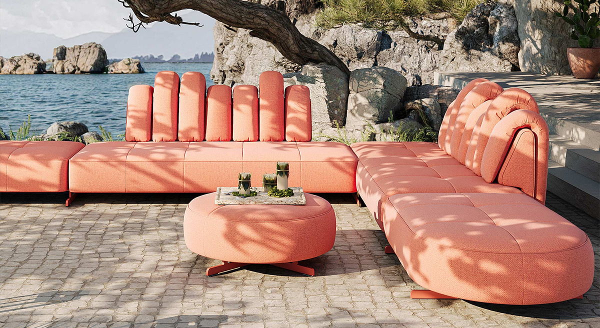 Outdoor seating area with coral-colored furniture by the water.