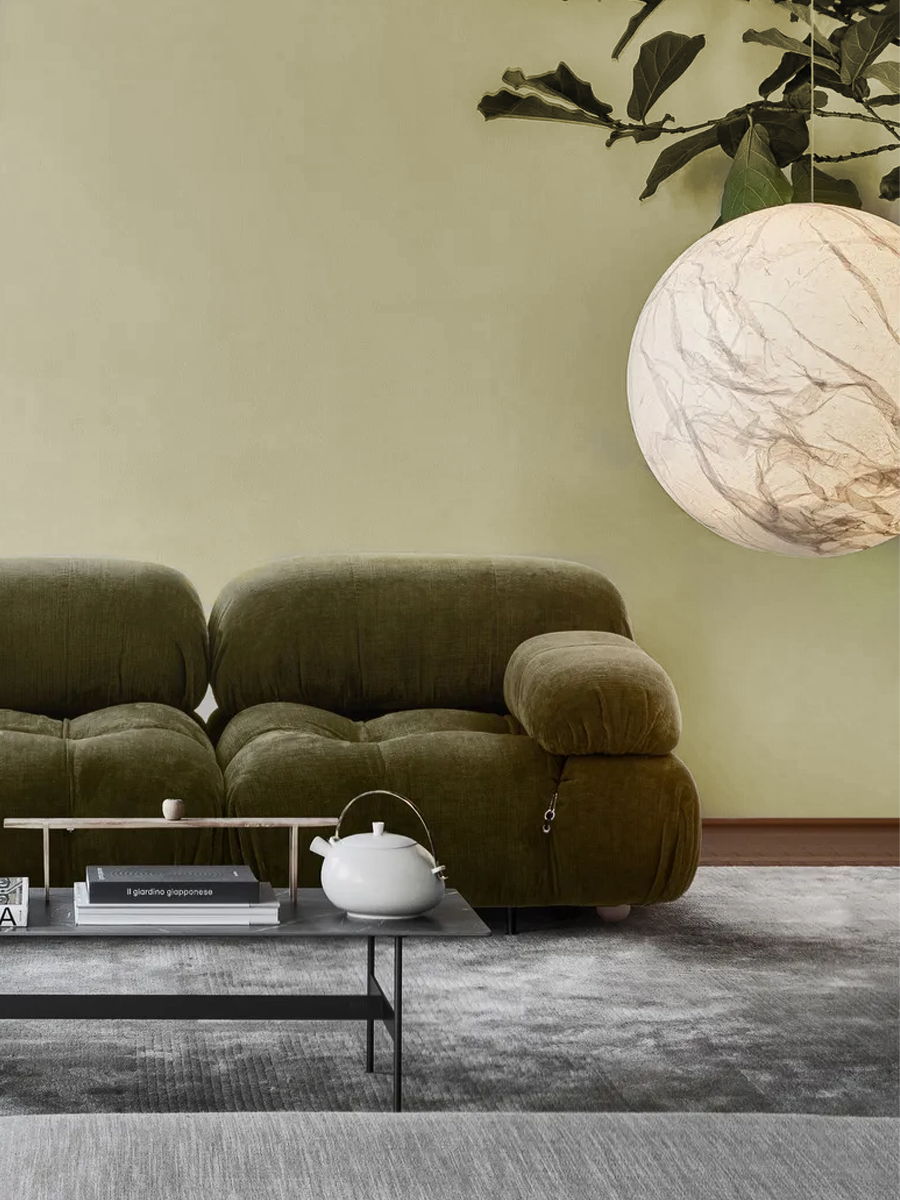 Cozy living room with plants, B&B Italia Camaleonda sofa, and a glass coffee table.