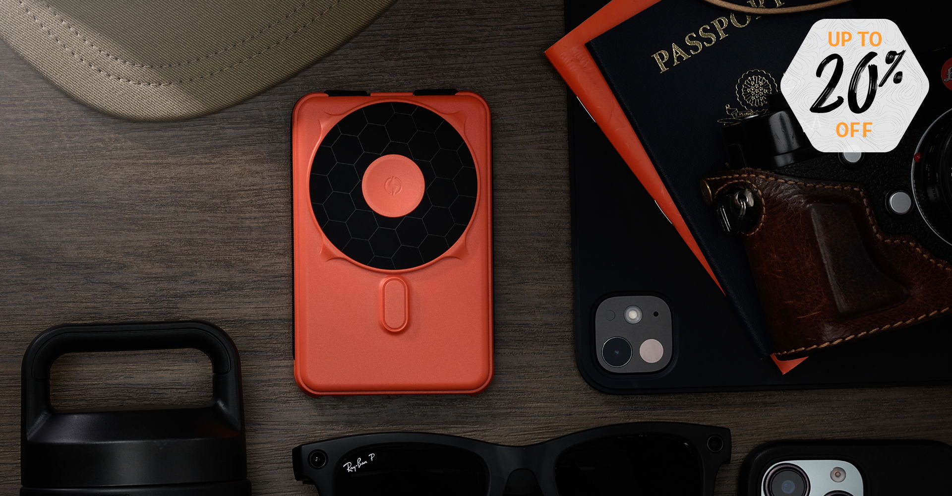 Orange camera on a wooden surface with accessories and a discount tag.
