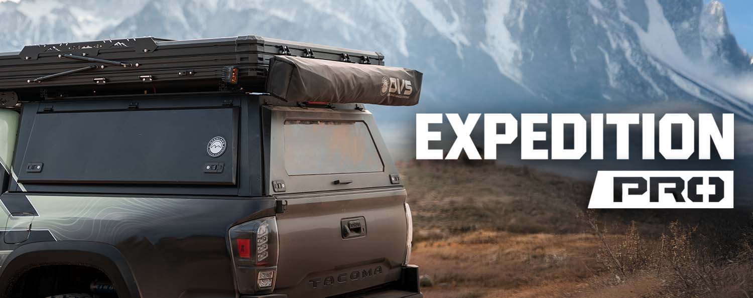 A vehicle with a rooftop tent in a mountainous landscape.