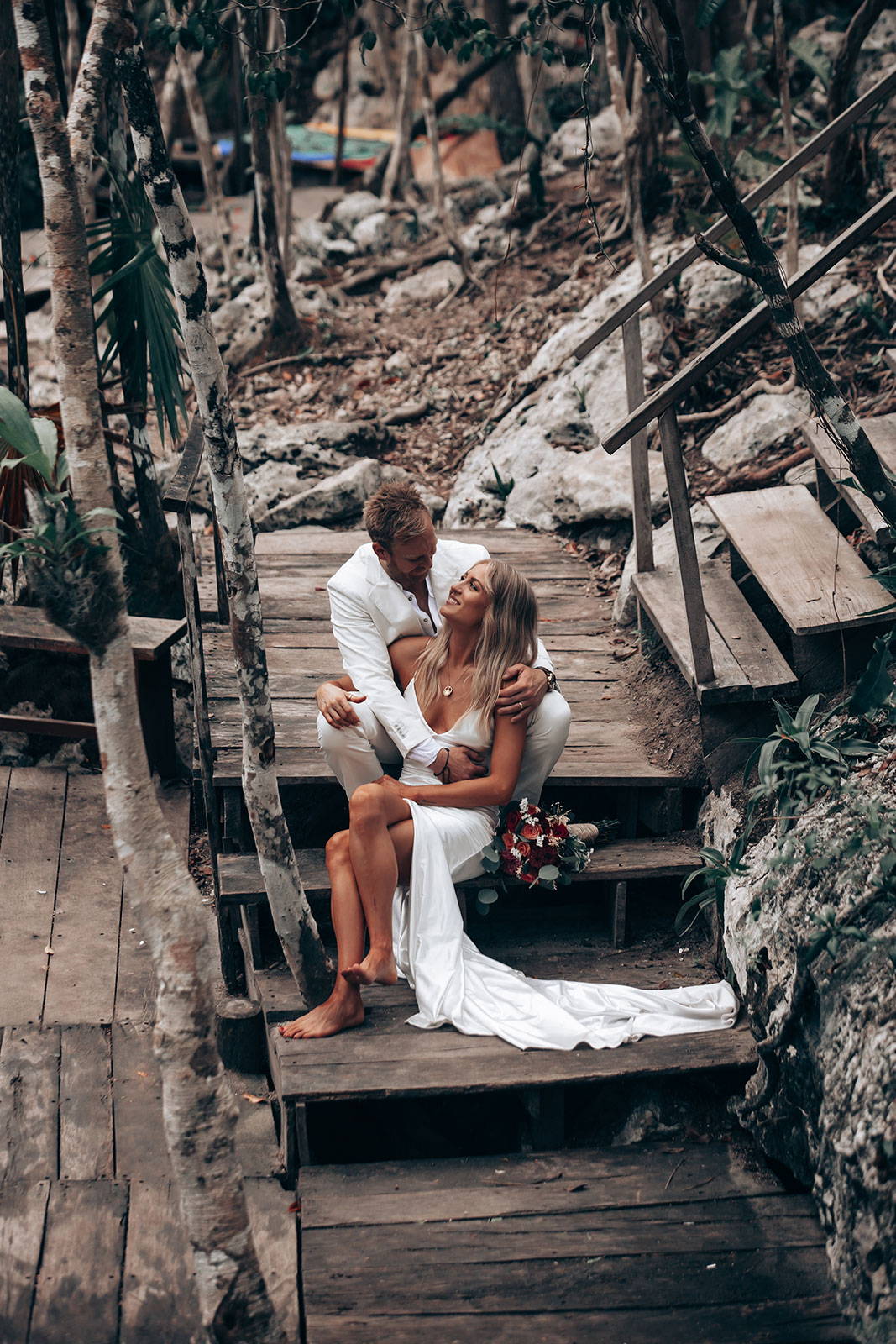 Bride and groom sitting on wooden staircase