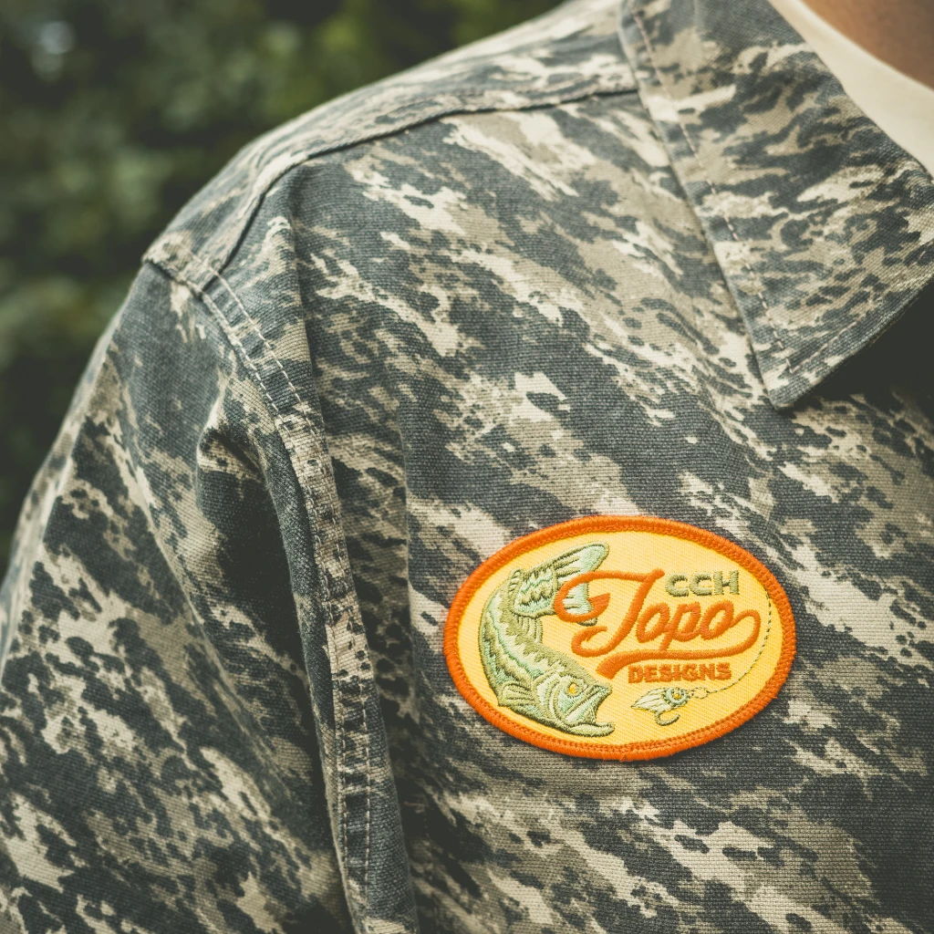 Military-style shirt with a colorful fishing patch on the shoulder.