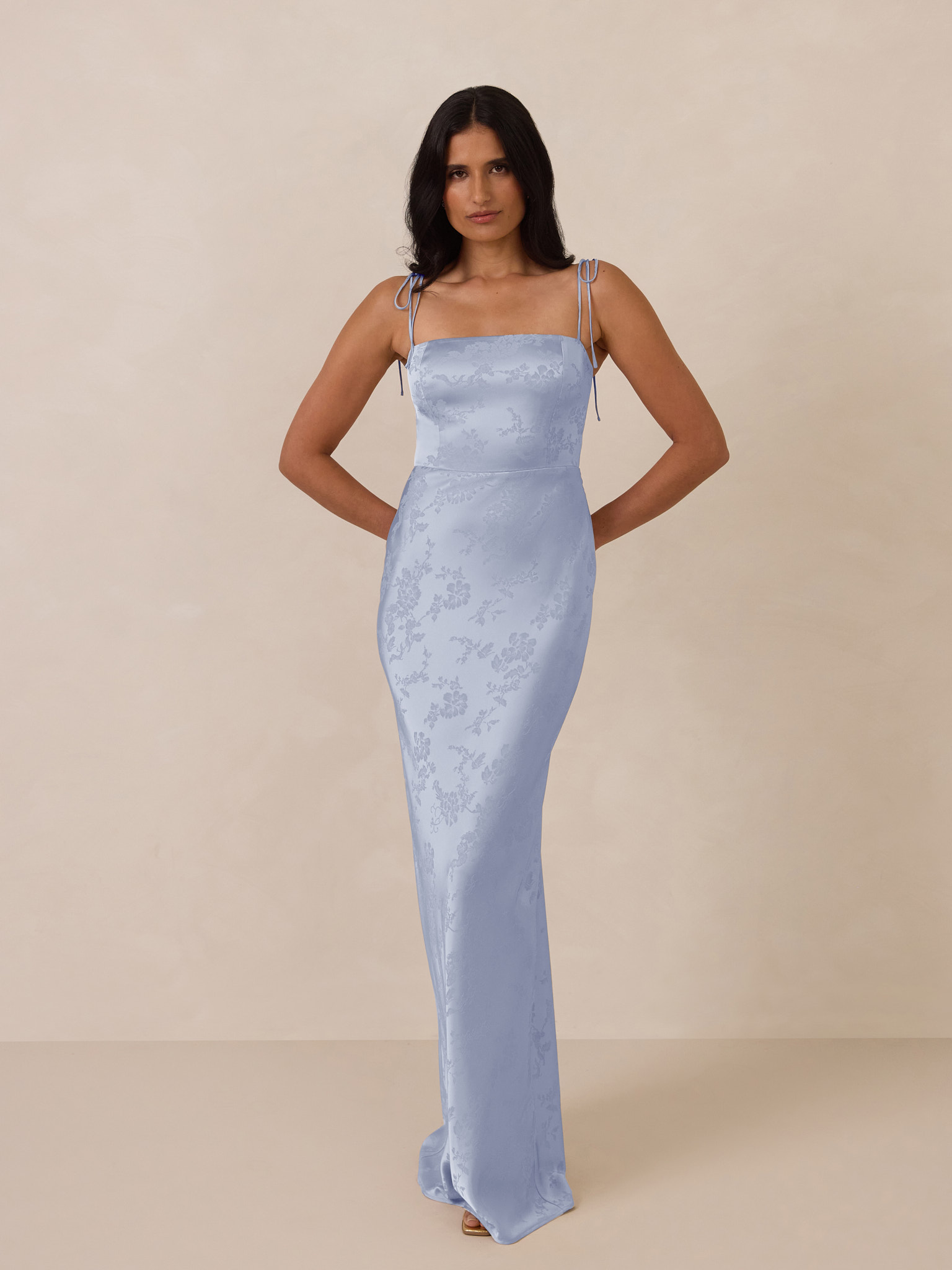 Model in a light blue evening gown against a neutral background.