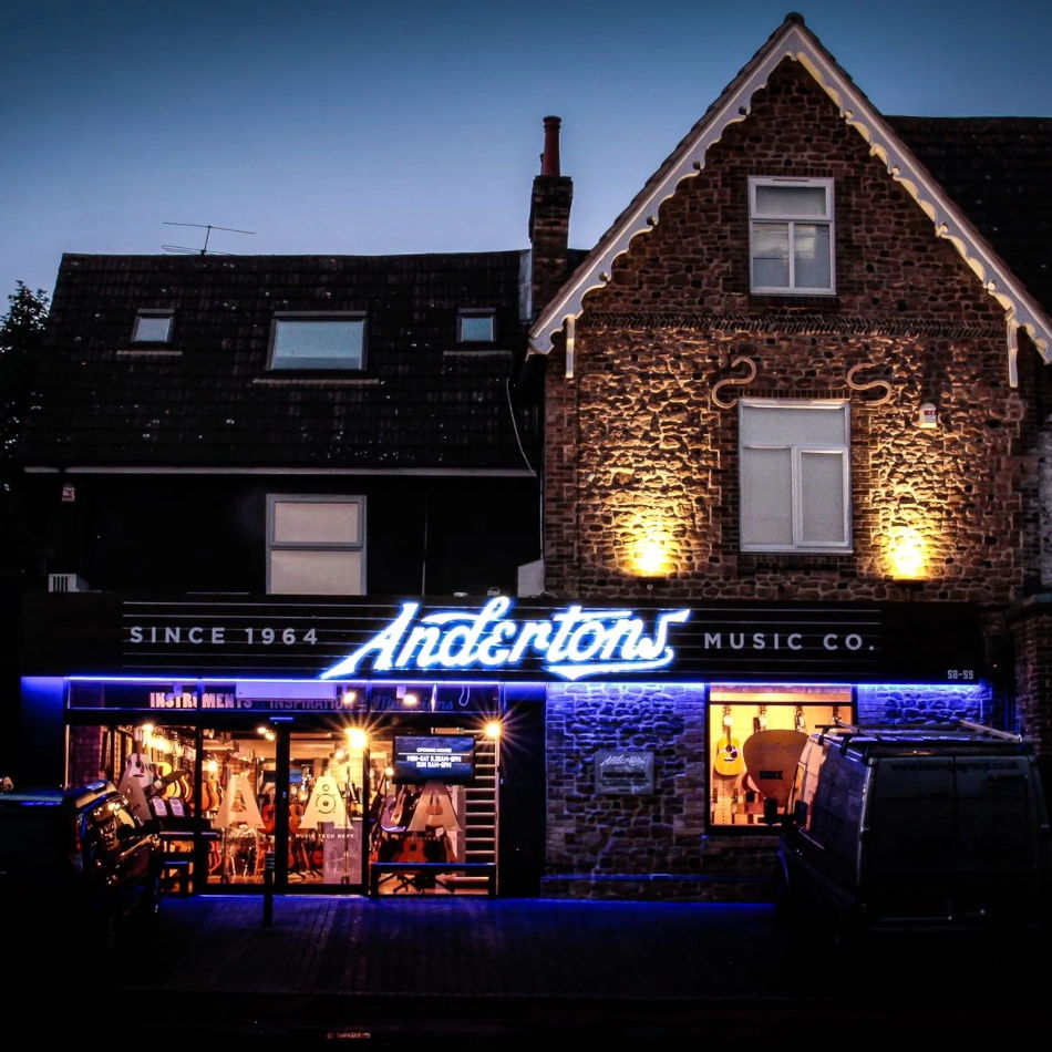 Andertons Music Co. storefront illuminated at night with blue signage.