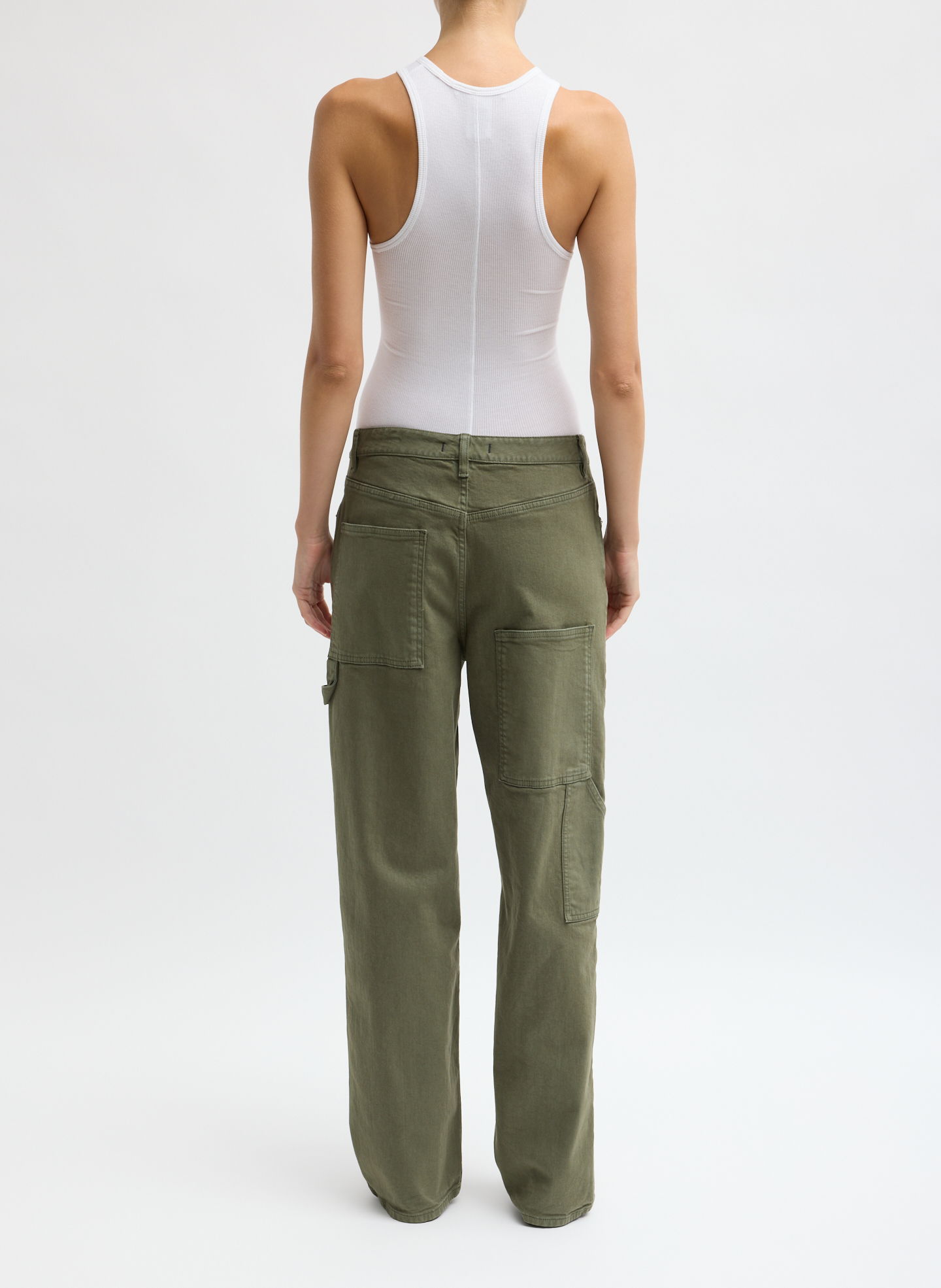 Person wearing a white tank top and olive green cargo pants, viewed from behind.