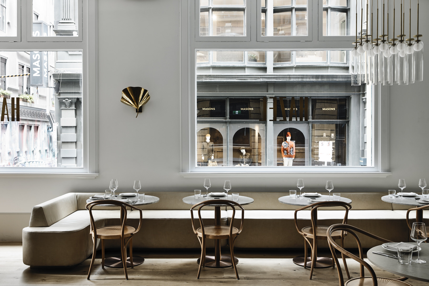 Modern restaurant interior with a golden wall light and pendants