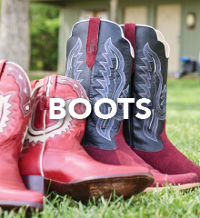 Red and black cowboy boots on grass.