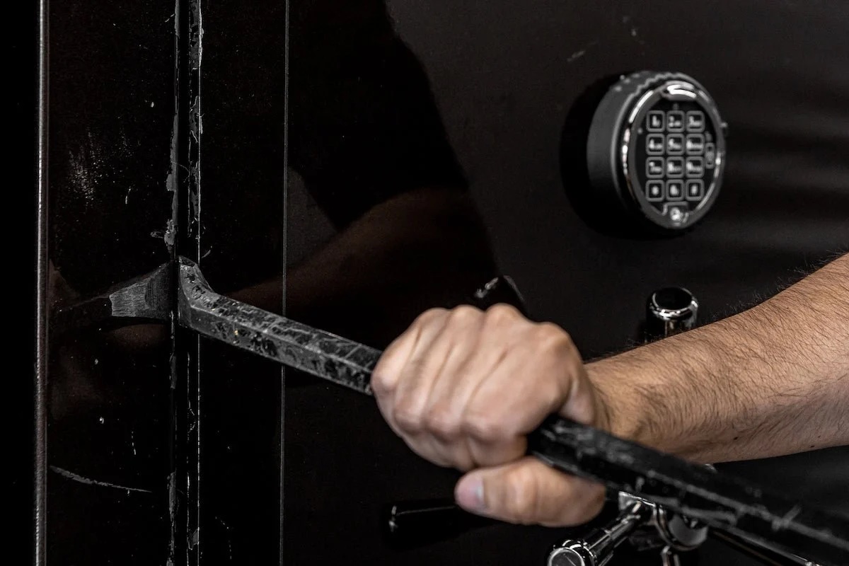 opening a safe with a crowbar.