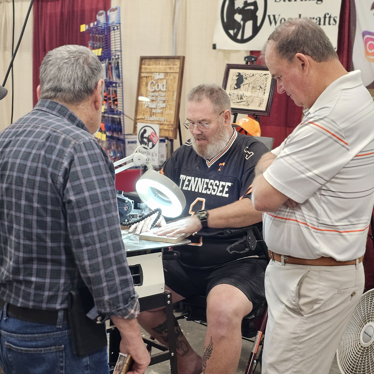 Three men discussing a craft project at a workshop event.