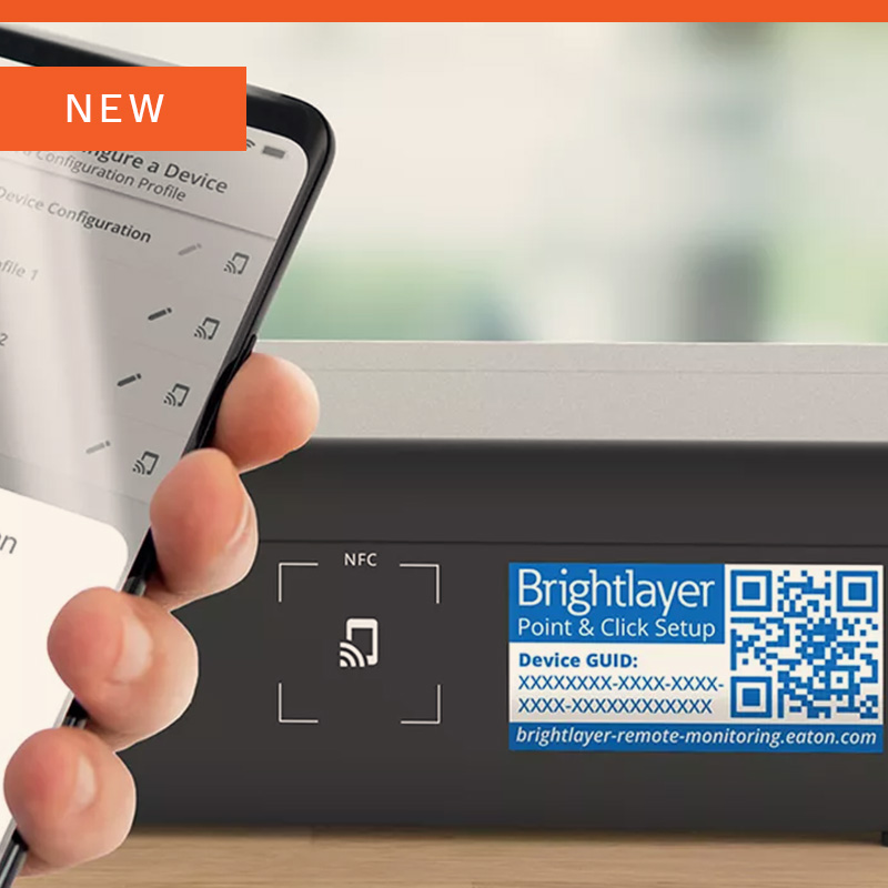Hand holding a smartphone near a device with a QR code.