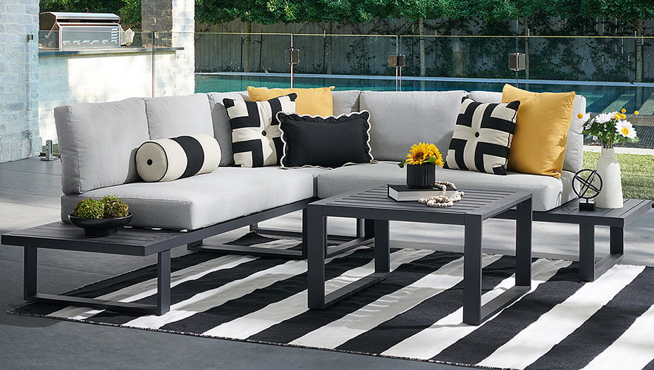 Outdoor seating area with gray cushions, black and white accents, and a coffee table.