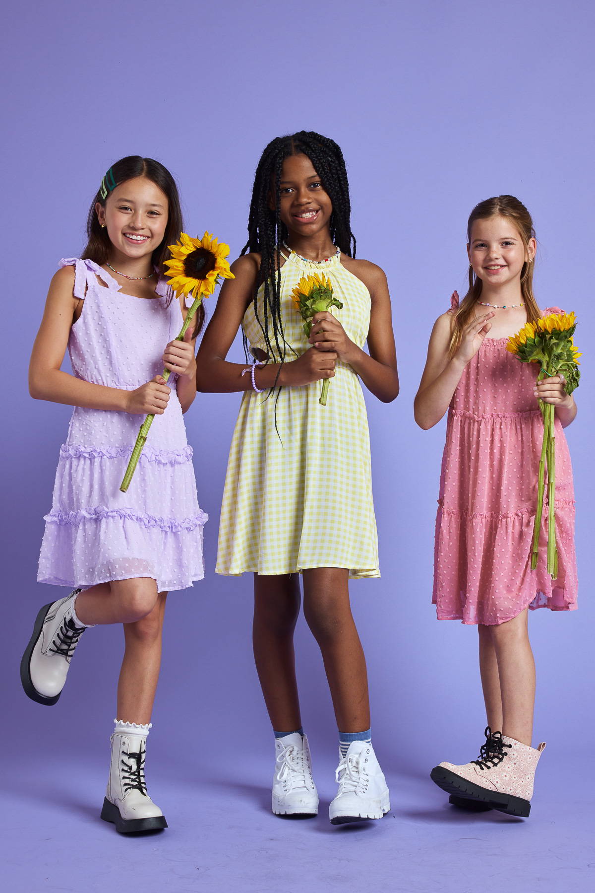 Trixxi Girl, kids collection, three young girls in Trixxi colorful dresses holding sunflowers.