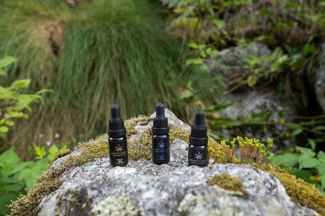 a group of three bottles sitting on top of a rock