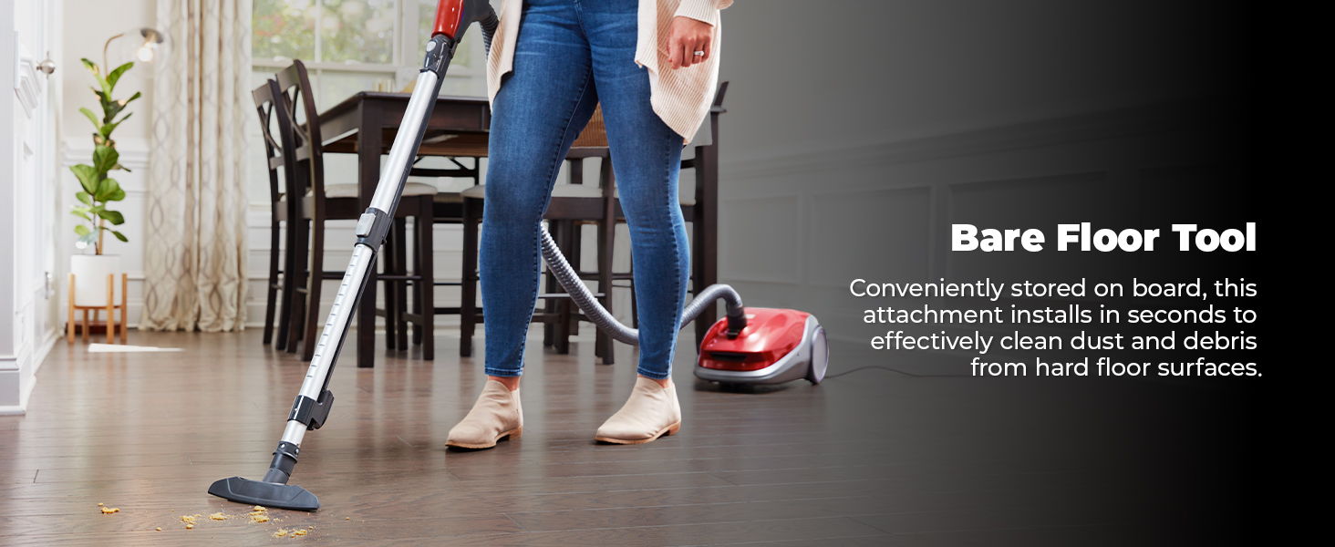 Person using a vacuum with a bare floor tool on hardwood floors.