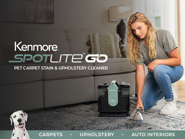 Woman cleaning carpet with Kenmore Spotlite Go stain cleaner. Dog in foreground.