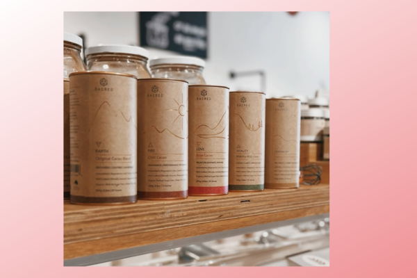 A row of cylindrical containers on a wooden shelf.