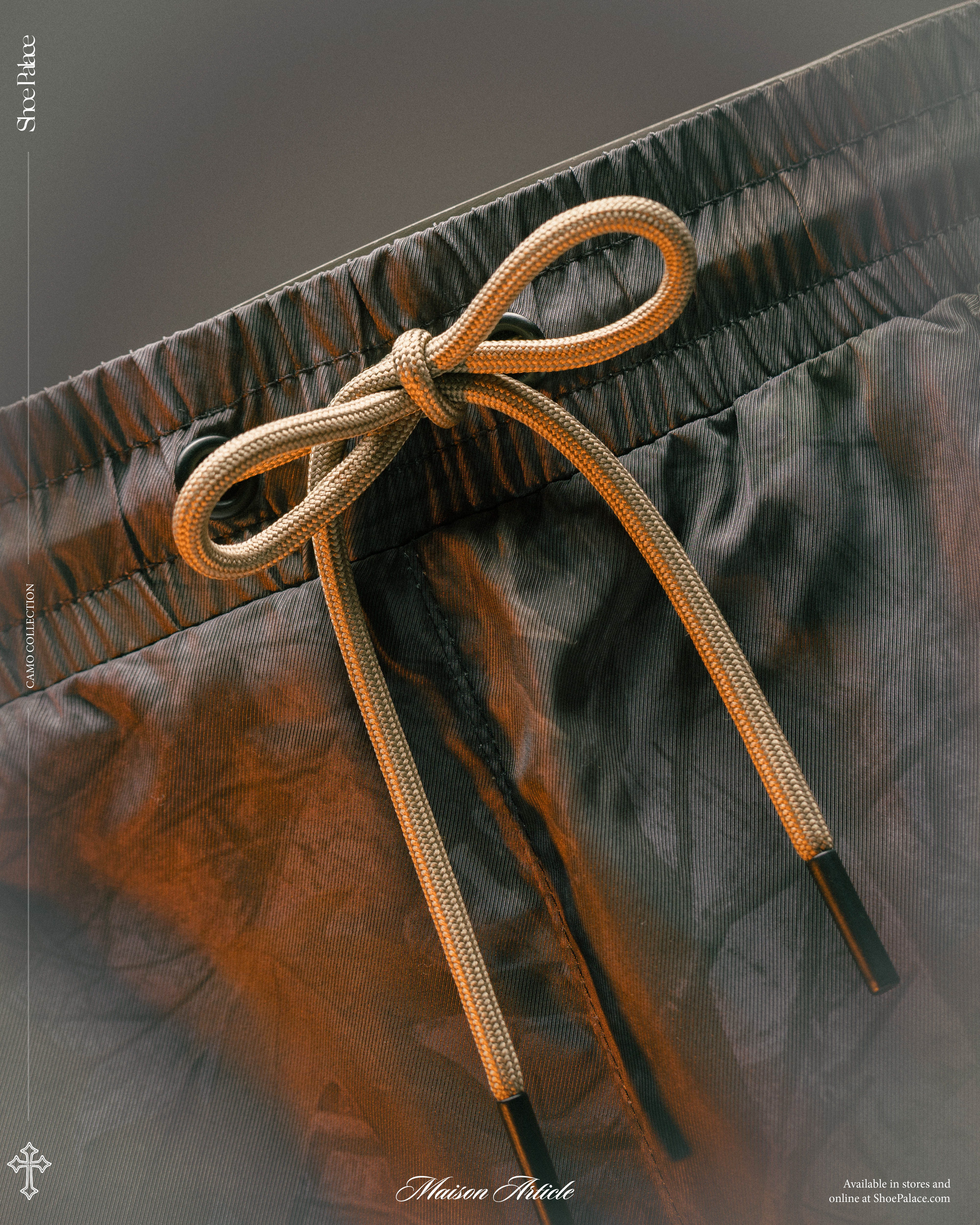 Close-up of a bow knot on the waistband of black shorts.