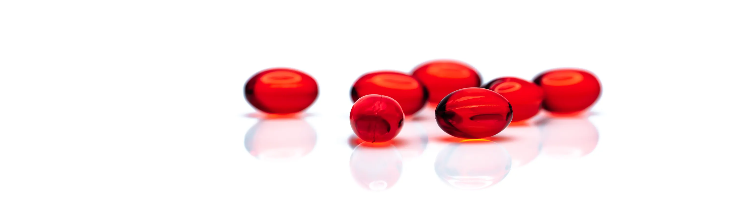 Heart-healthy red krill oil softgels on white background.