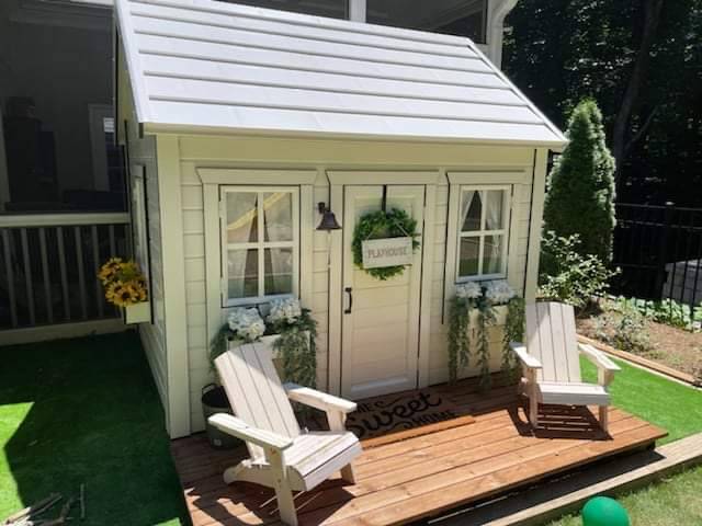 Close up of the wooden terrace with white chairs and a door with decoration of Kids Outdoor Playhouse Arctic Nario by WholeWoodPlayhouses 