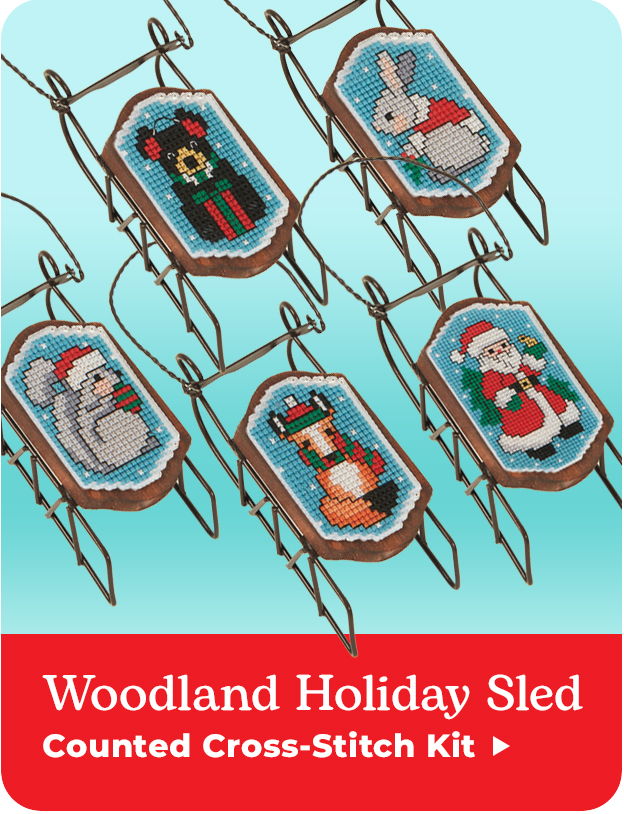 Woodland holiday sled with cross-stitch patterns of animals and Santa. Counted Cross-Stitch Kit.