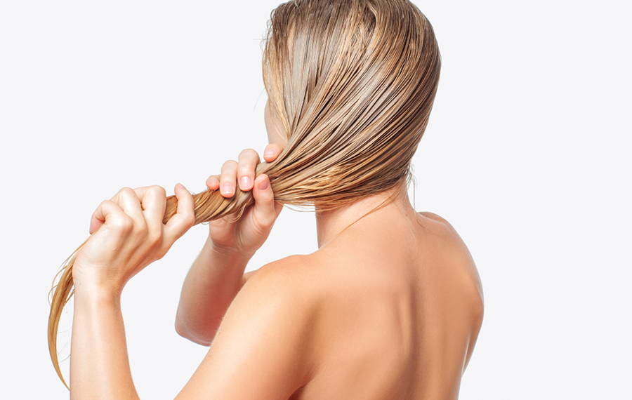 woman applying castor oil to her hair