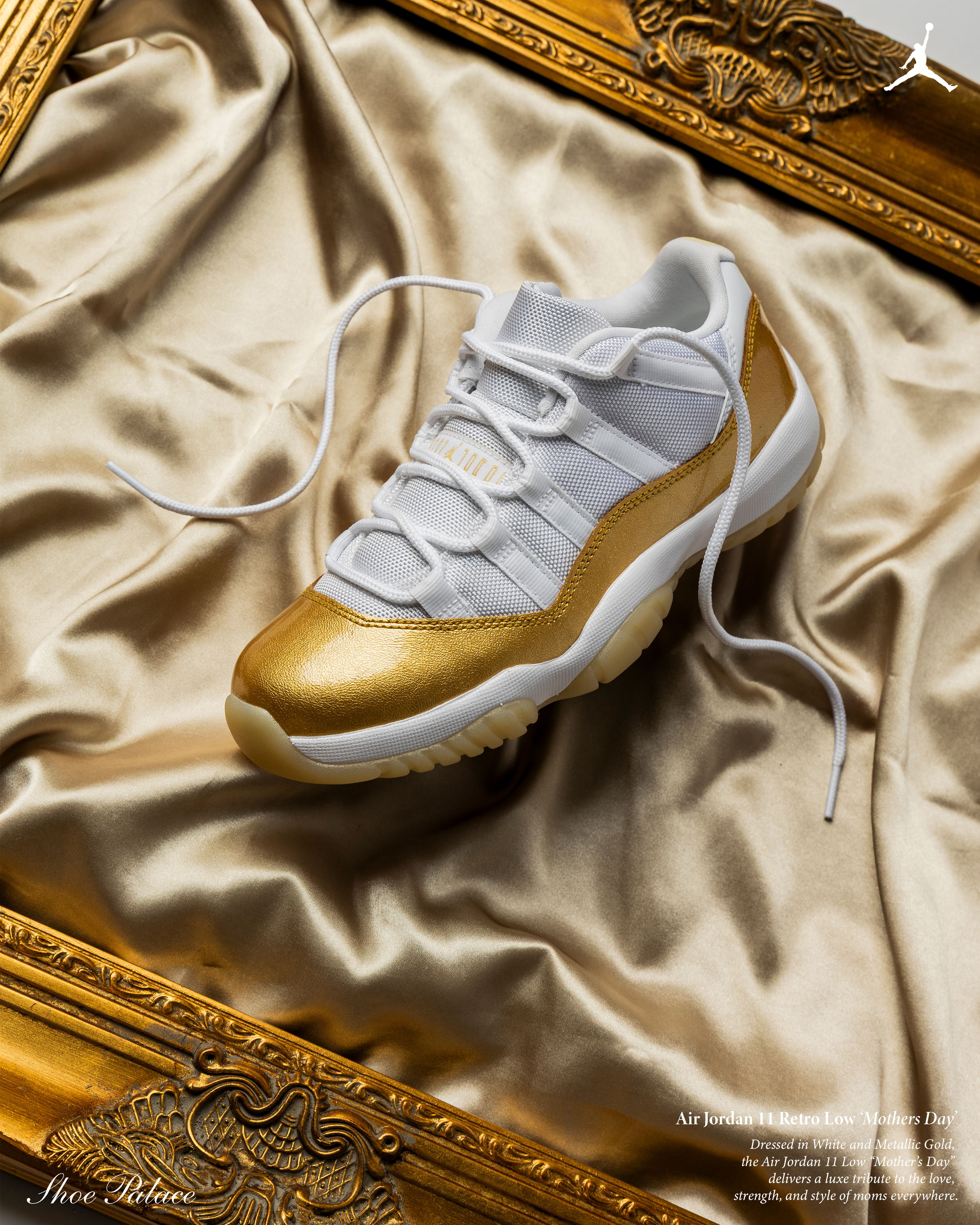 A white and gold sneaker displayed on satin fabric in a gold frame.