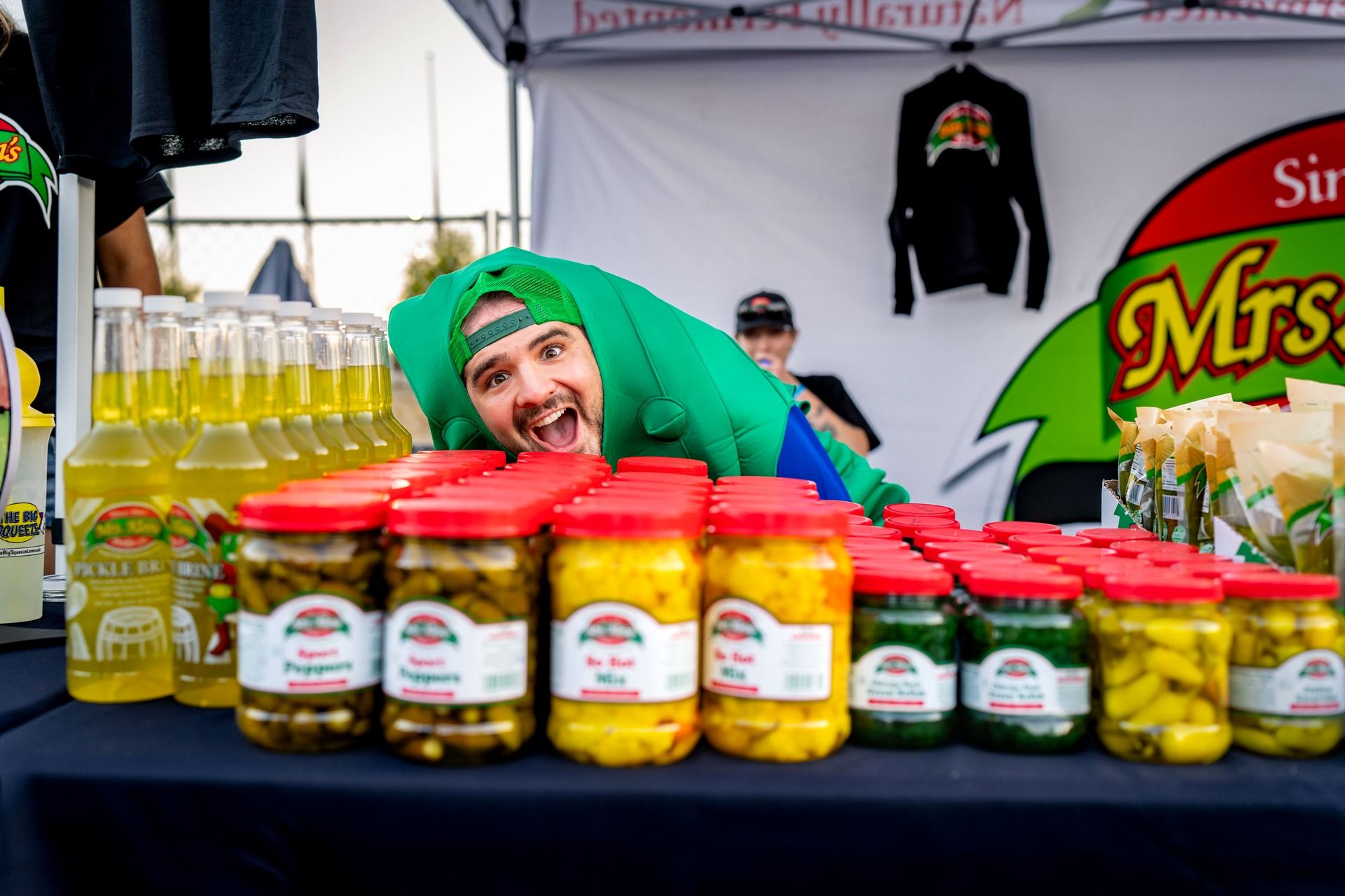 The Mrs. Klein's naturally fermented pickle vendor activation features hot peppers, sweet pickles, pickle brine, and Big Squeeze pickle lemonade at the World's Largest Pickle Party at The Big Dill pickle festival, Globe Life Field and Texas Live!, Arlington Texas 2025.