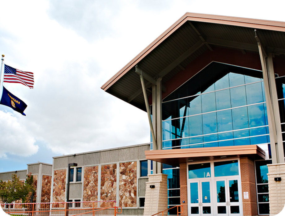 Modern building with large windows and flags outside.