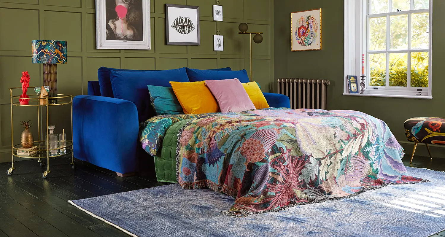 Snug cloud sundae 3 seater sofa bed in midnight blue with bright printed blankets and cushions