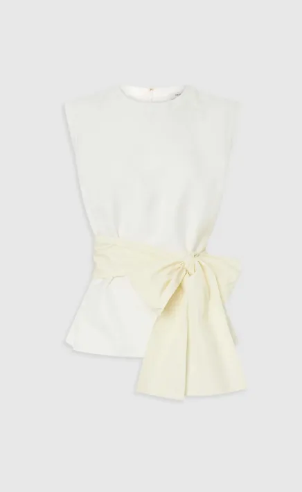 White top with a cream bow accent at the waist.