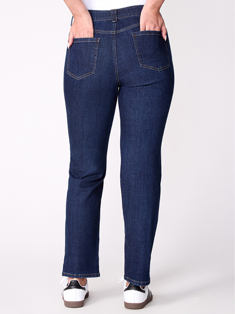 Woman wearing dark blue jeans and white sneakers.