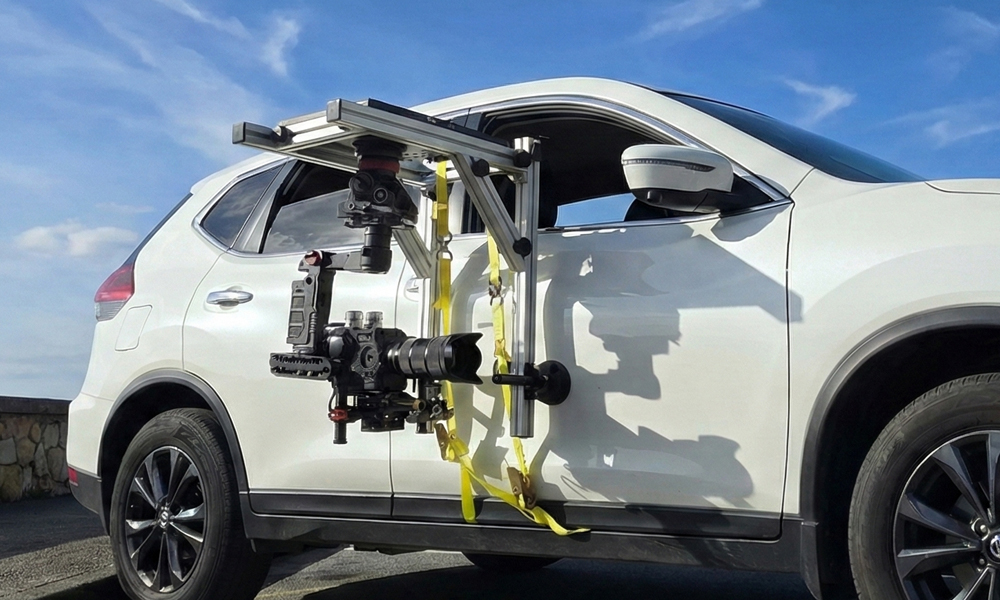 Camera rig mounted on the side of a white SUV.