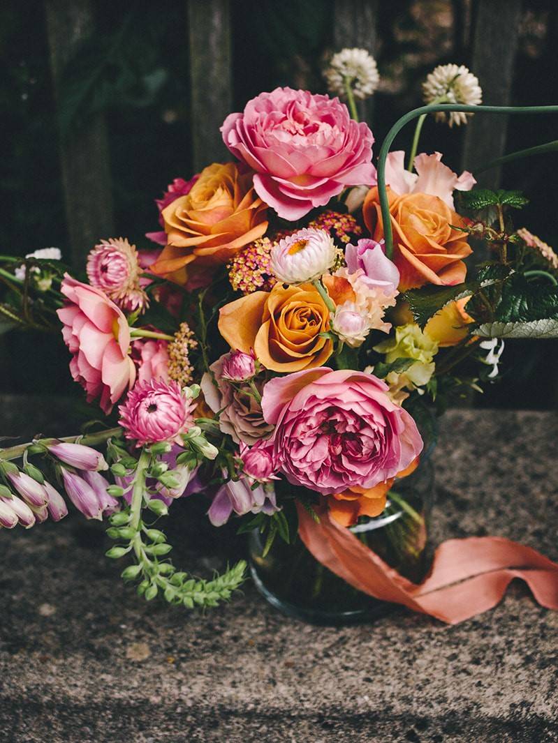 A bouquet of British grown wild and ornamental flowers in pinks and oranges, styled by Wildflower Florist and photographed by The Twins Photography in Newcastle