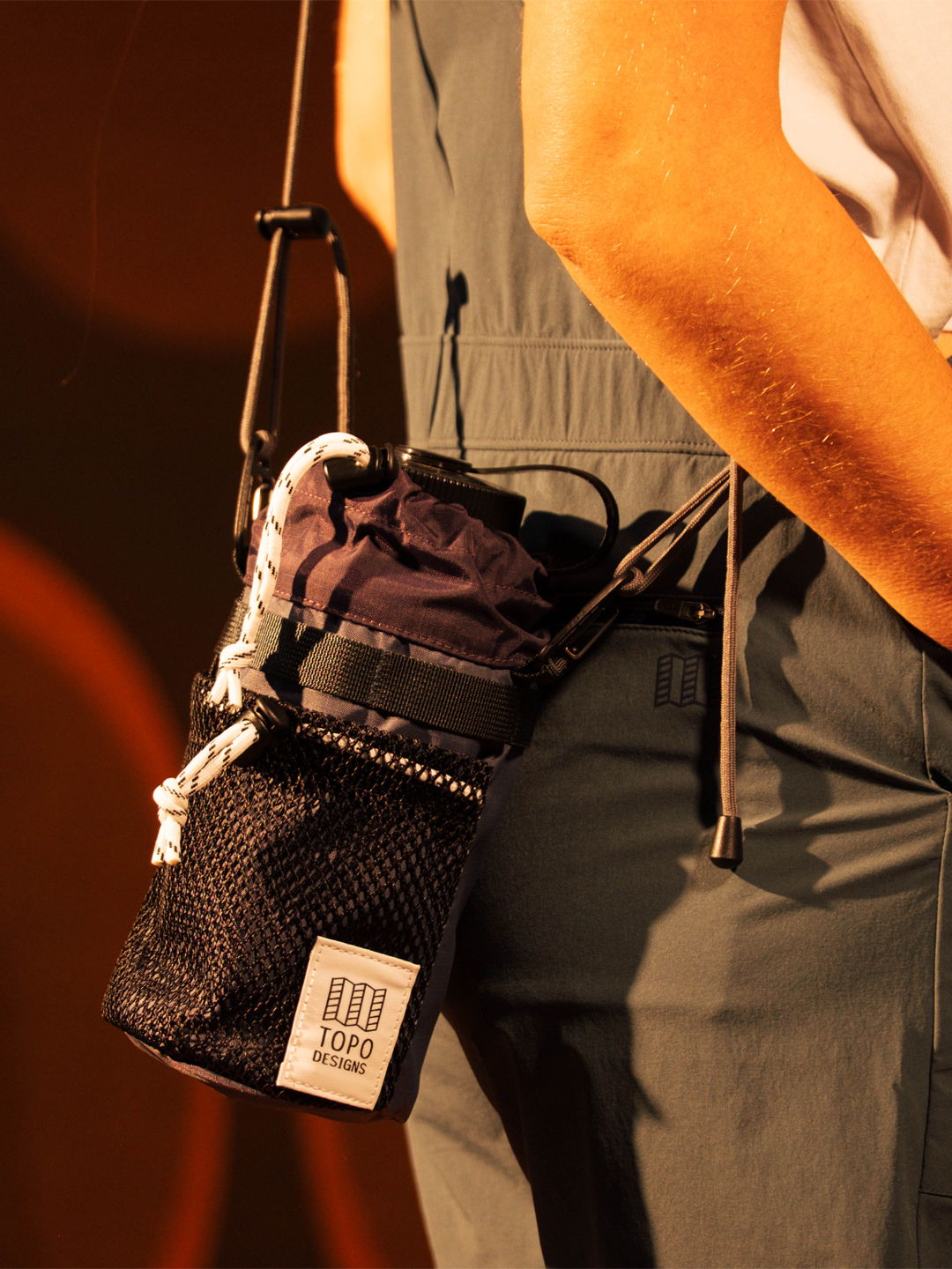 A person holding a small bag with a drink and accessories.