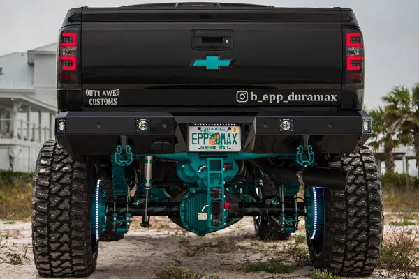 Rear straight-on view of Brandon's black lifted 2018 Chevrolet Silverado 2500 with teal suspension and horn installation underneath, photo 4