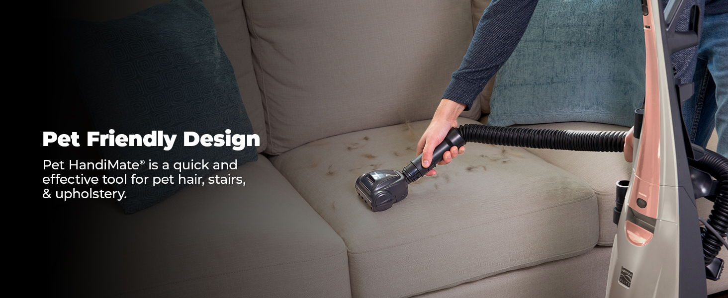 Person using vacuum on couch, highlighting pet-friendly design features.